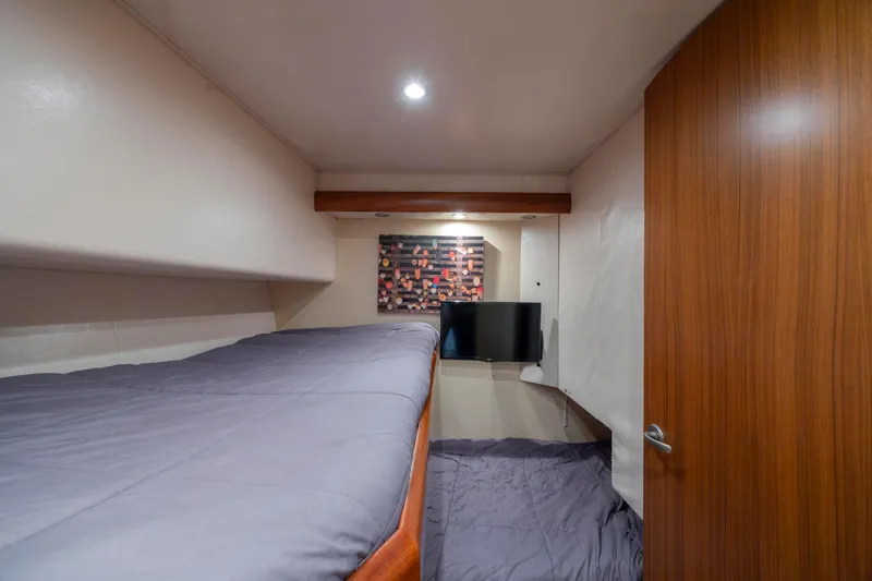 Slide: The Image of 2009 Viking 60 Convertible yacht cabin with bed, TV, and modern decor. - 81