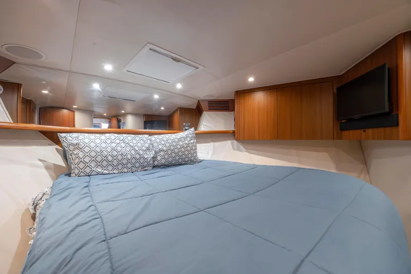 Slide: The Image of Luxurious cabin interior of 2009 Viking 60 Convertible yacht with cozy bedding and wood accents. - 96
