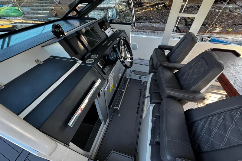 Slide: The Image of 2017 Axopar 37 Sun Top boat interior with modern dashboard and comfortable seating. - 14