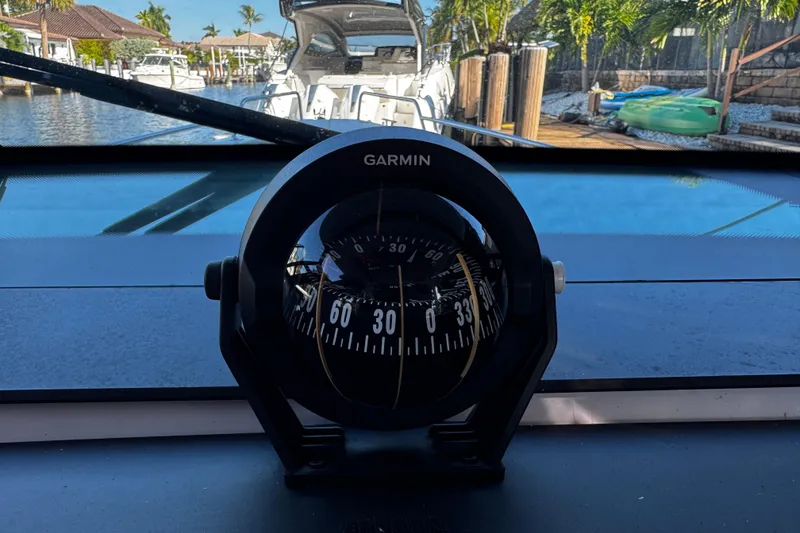 Slide: The Image of Garmin compass on 2017 Axopar 37 Sun Top boat, docked near waterfront homes. - 29