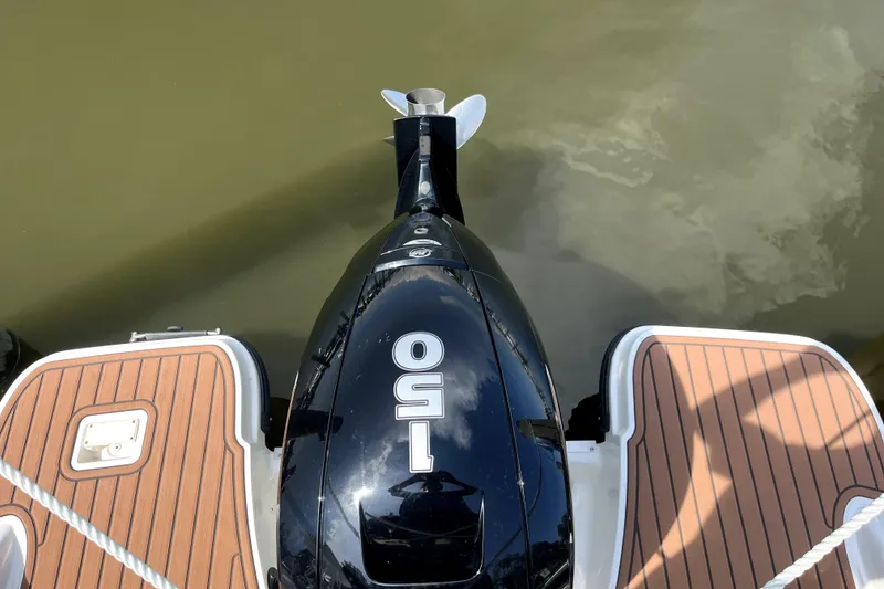 Slide: The Image of 2024 Trophy CC22 boat with 150 HP engine, wooden deck, and water reflection. - 5