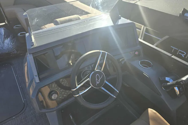 Slide: The Image of Steering console of 2026 Qwest 8524 Q3XA boat with modern controls and cup holder. - 12