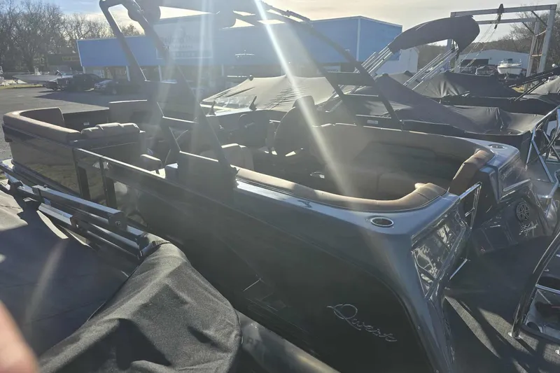 Slide: The Image of 2026 Qwest 8524 Q3XA pontoon boat in a sunny outdoor showroom. - 8