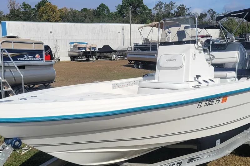 Slide: The Image of 2011 Sundance SV186 boat on trailer, displayed outdoors with other boats. - 3