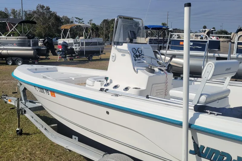 Slide: The Image of 2011 Sundance SV186 boat on trailer, displayed outdoors with other boats. - 5