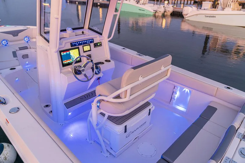 Slide: The Image of Manufacturer Provided Image: 2026 Sailfish 232 CC boat interior with illuminated console and seating at a marina. - 14