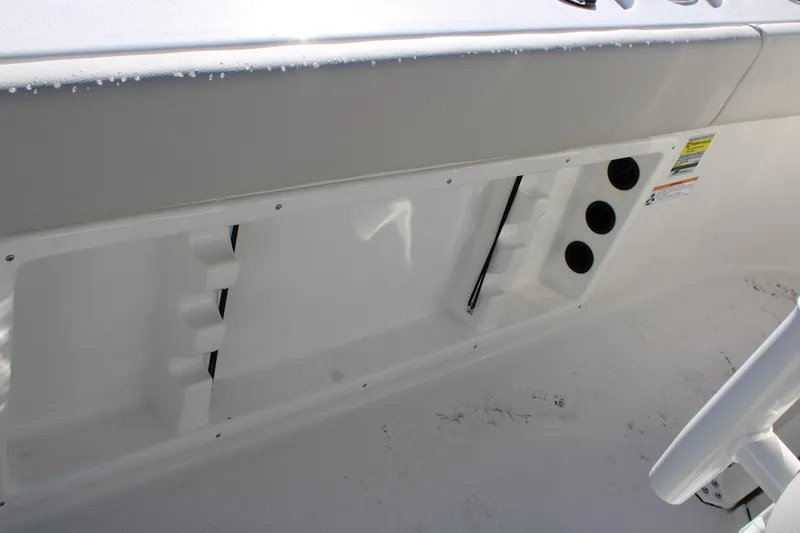 Slide: The Image of 2026 Sailfish 232 CC boat interior detail with storage compartment and rod holders. - 22