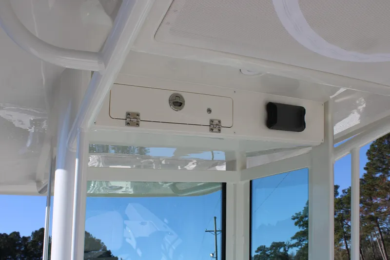 Slide: The Image of 2026 Sailfish 232 CC boat interior detail with storage compartment and window view. - 25