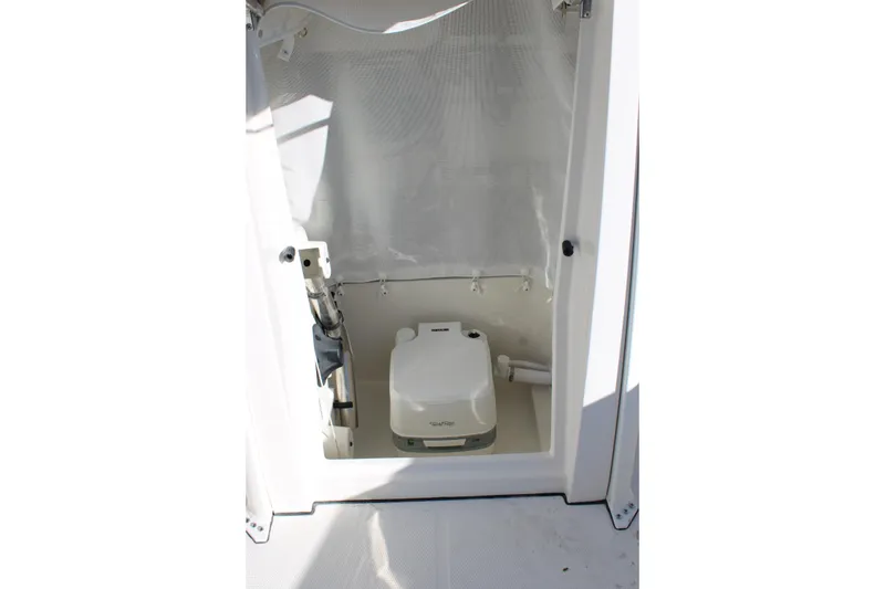 Slide: The Image of Interior of 2026 Sailfish 232 CC boat featuring a compact marine toilet. - 29
