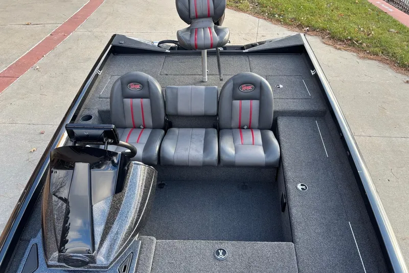 Slide: The Image of 2017 Ranger RT178C boat interior with gray and red seats, parked on pavement. - 12