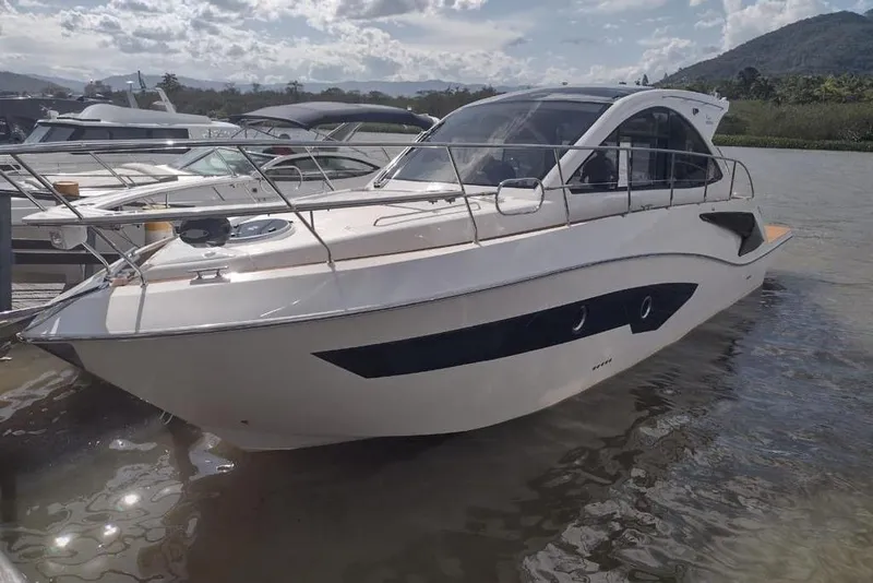 Slide: The Image of 2023 Evolve 400HT yacht docked on a sunny day with scenic background. - 1