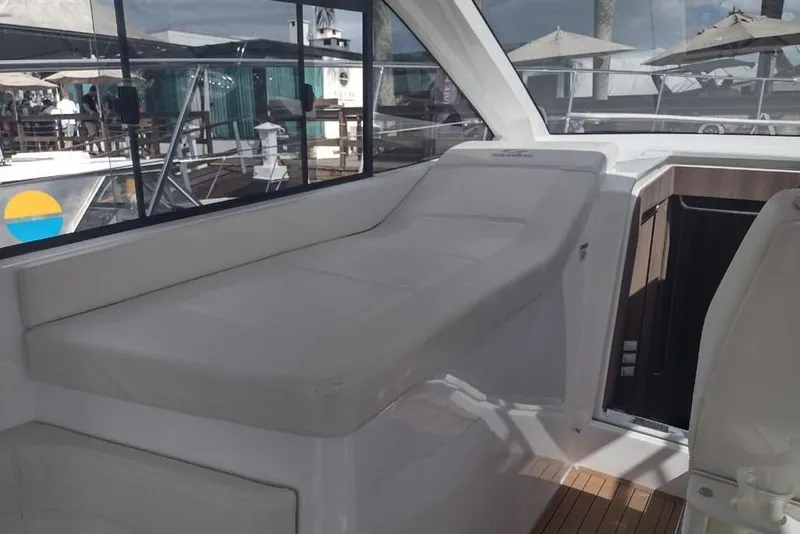 Slide: The Image of 2023 Evolve 400HT yacht interior with white seating and wooden flooring. - 11