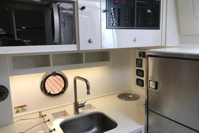 Slide: The Image of Modern kitchen interior of 2023 Evolve 400HT yacht with sink, microwave, and control panel. - 13