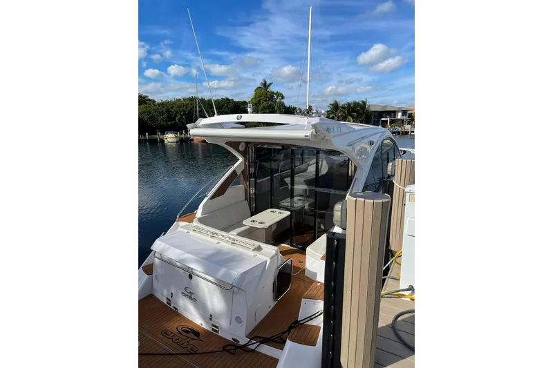 Slide: The Image of 2023 Evolve 400HT yacht docked by a serene waterfront under a blue sky. - 15
