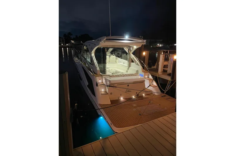 Slide: The Image of 2023 Evolve 400HT yacht docked at night with illuminated deck and interior. - 16