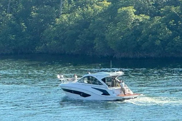 Slide: The Image of 2023 Evolve 400HT yacht cruising on a serene, tree-lined waterway. - 2