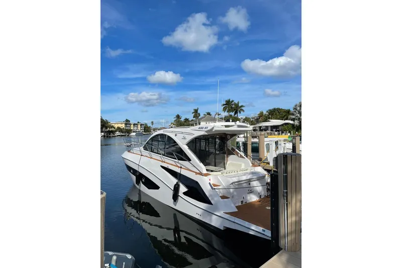 Slide: The Image of 2023 Evolve 400HT yacht docked in a sunny marina with palm trees. - 3