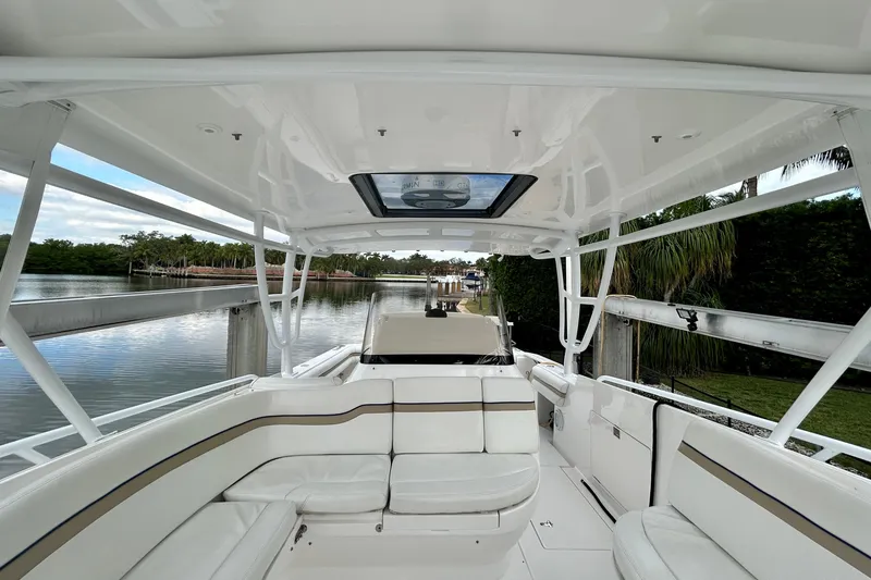 Slide: The Image of 2012 Intrepid 400 Cuddy boat interior with white seating and scenic waterway view. - 19