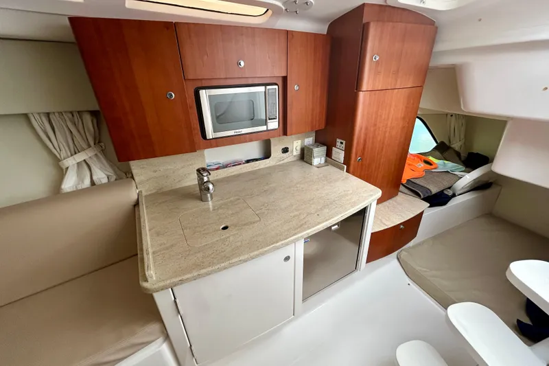 Slide: The Image of 2012 Intrepid 400 Cuddy interior with kitchenette, microwave, and seating area. - 25