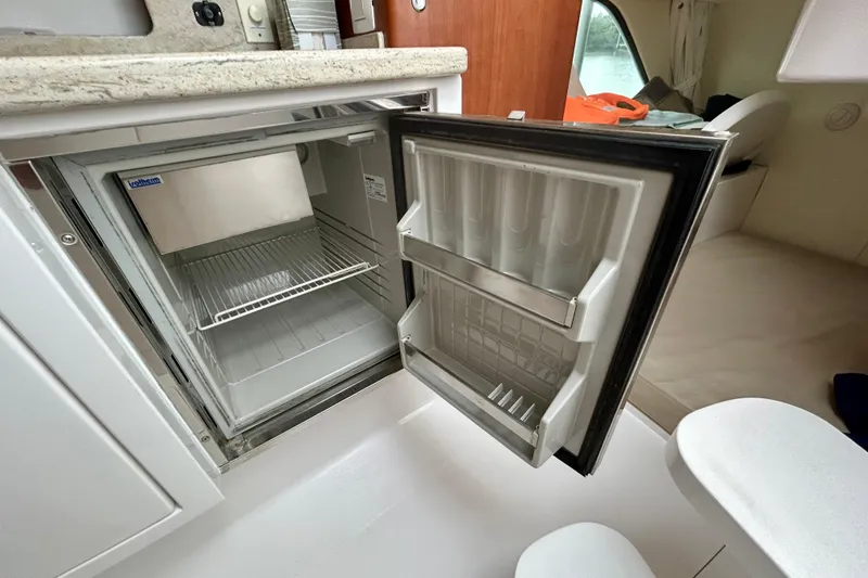 Slide: The Image of Open refrigerator inside 2012 Intrepid 400 Cuddy boat cabin, showcasing interior space. - 26