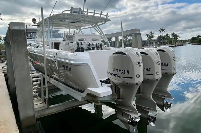 Slide: The Image of 2012 Intrepid 400 Cuddy boat with triple Yamaha engines docked by the water. - 3
