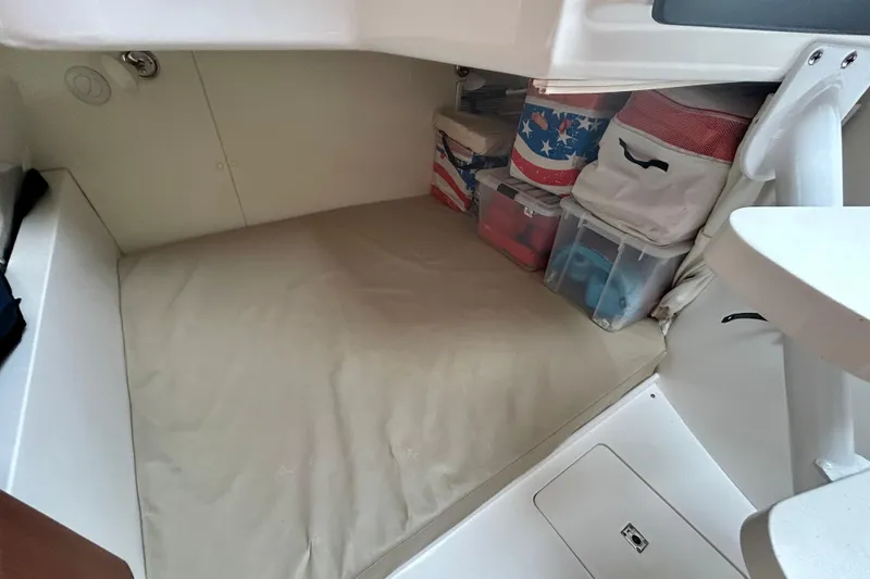 Slide: The Image of Cozy cabin storage area in 2012 Intrepid 400 Cuddy boat, featuring organized containers. - 32