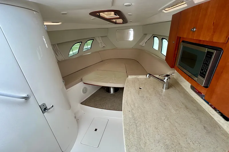 Slide: The Image of Interior of 2012 Intrepid 400 Cuddy, featuring kitchenette and seating area. - 34