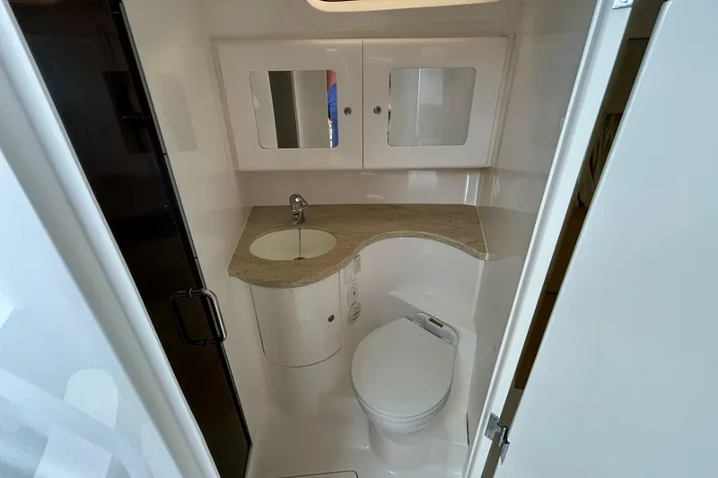 Slide: The Image of 2012 Intrepid 400 Cuddy bathroom with sink, toilet, and mirrored cabinet. - 37