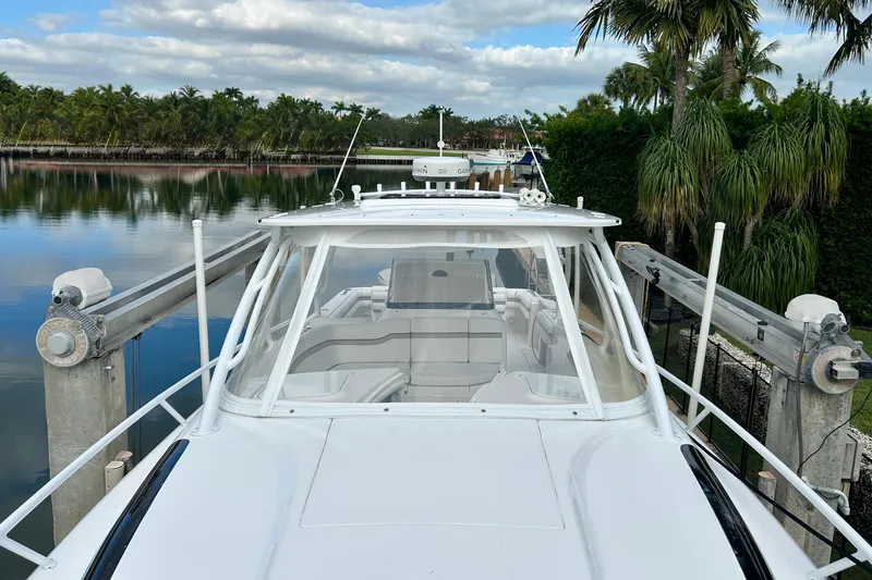 Slide: The Image of 2012 Intrepid 400 Cuddy boat docked by tropical waterfront. - 41