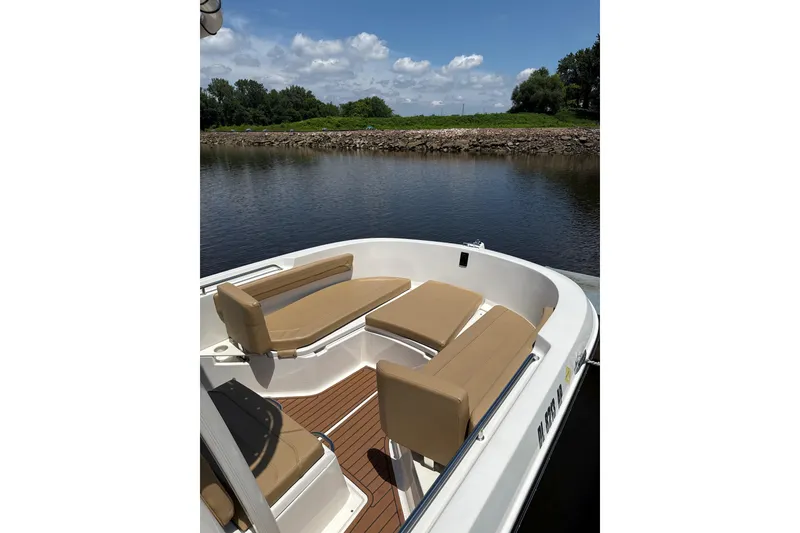 Slide: The Image of 2024 Trophy CC22 boat interior with tan seating, docked by a calm river. - 4