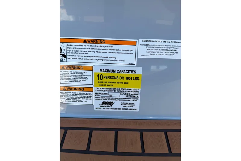 Slide: The Image of 2024 Trophy CC22 capacity label, warning signs, and emissions information on boat surface. - 9
