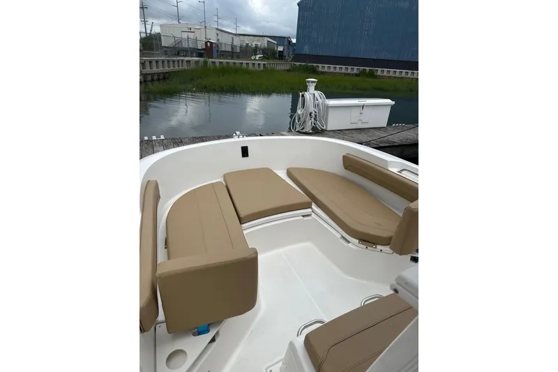 Slide: The Image of 2024 Trophy CC22 boat with tan seating, docked near a calm waterway. - 5