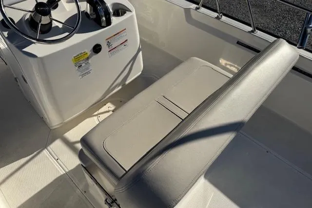 Slide: The Image of 2023 Boston Whaler 170 Montauk boat interior with steering console and cushioned seating. - 13