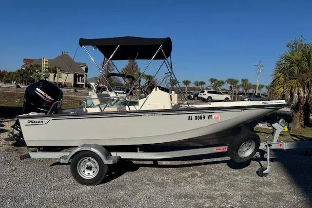 Slide: The Image of 2023 Boston Whaler 170 Montauk boat on trailer, parked outdoors under clear blue sky. - 3