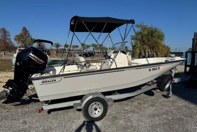 Slide: The Image of 2023 Boston Whaler 170 Montauk boat on trailer with Mercury engine, parked outdoors. - 4
