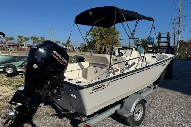 Slide: The Image of 2023 Boston Whaler 170 Montauk boat on trailer with Mercury engine, parked outdoors. - 5