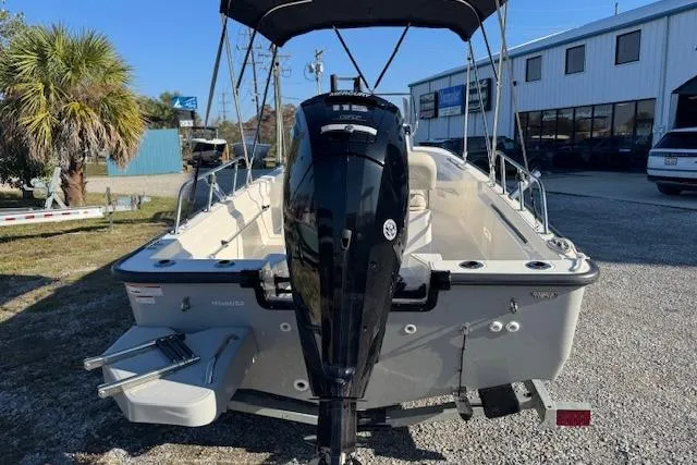 Slide: The Image of 2023 Boston Whaler 170 Montauk boat with outboard motor, parked outdoors. - 6