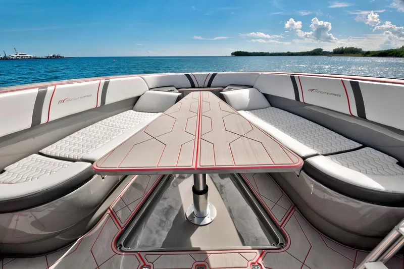 Slide: The Image of Luxurious 2023 Midnight Express 43 Open boat interior with sleek seating and table, ocean backdrop. - 18