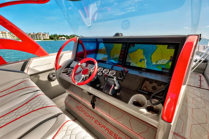 Slide: The Image of 2023 Midnight Express 43 Open boat cockpit with red accents and navigation screens. - 24