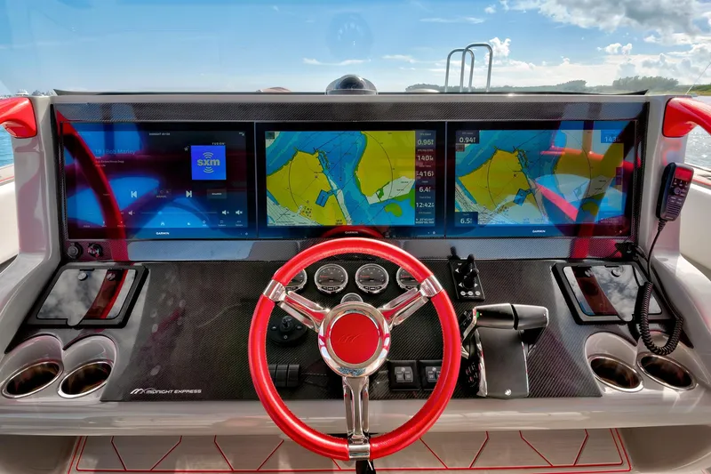 Slide: The Image of 2023 Midnight Express 43 Open dashboard with navigation screens and red steering wheel. - 25