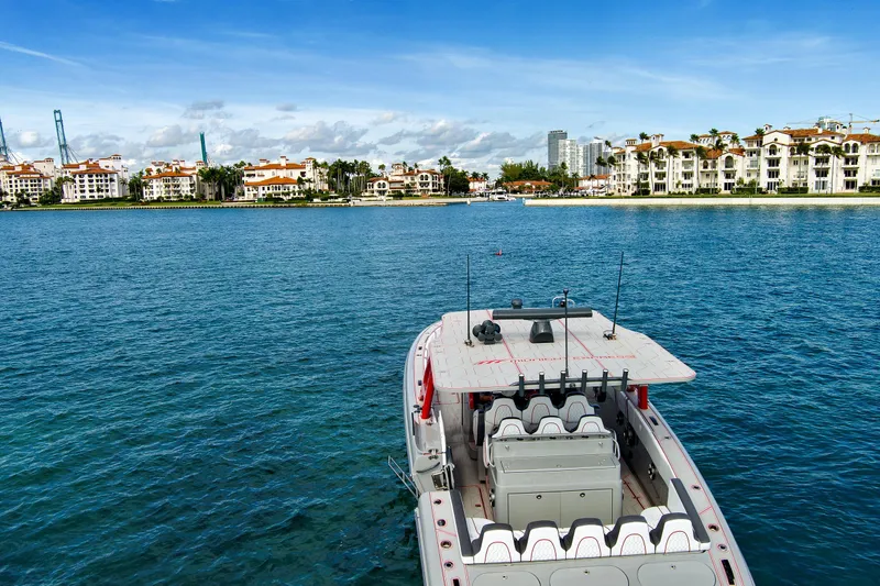 Slide: The Image of 2023 Midnight Express 43 Open boat on blue water with coastal buildings in the background. - 9