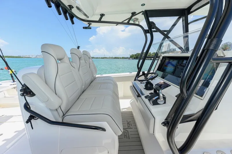 Slide: The Image of 2023 SeaVee 370Z boat interior with modern helm and seating, overlooking serene waters. - 12