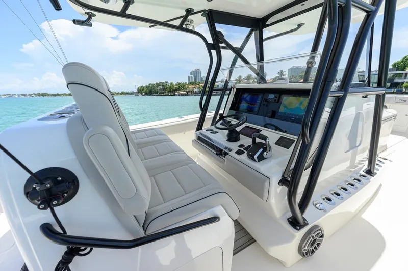 Slide: The Image of 2023 SeaVee 370Z boat cockpit with modern controls and seating, overlooking a scenic waterfront. - 13