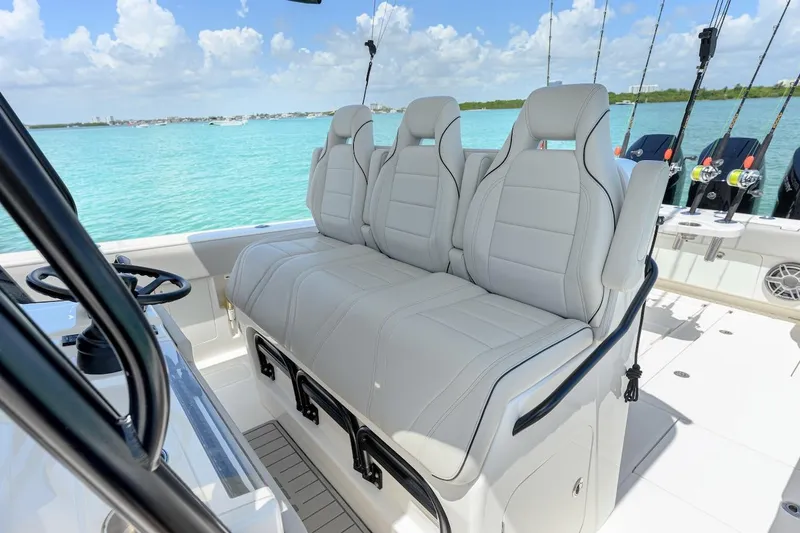 Slide: The Image of 2023 SeaVee 370Z boat interior with plush seating, ocean view, and fishing rods. - 14