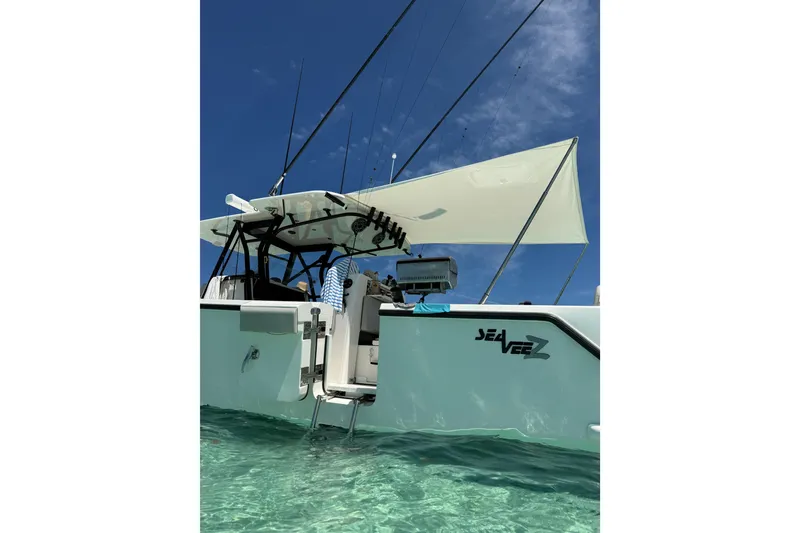 Slide: The Image of 2023 SeaVee 370Z boat in clear water, featuring fishing rods and canopy. - 23