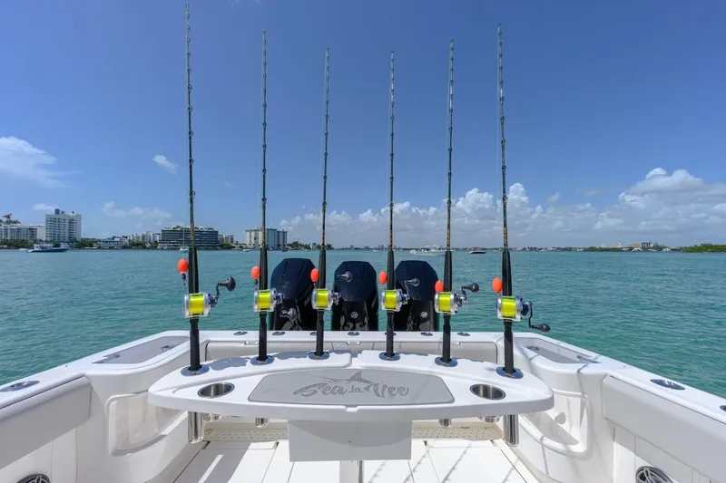 Slide: The Image of 2023 SeaVee 370Z boat with fishing rods, ocean view, and clear blue sky. - 5