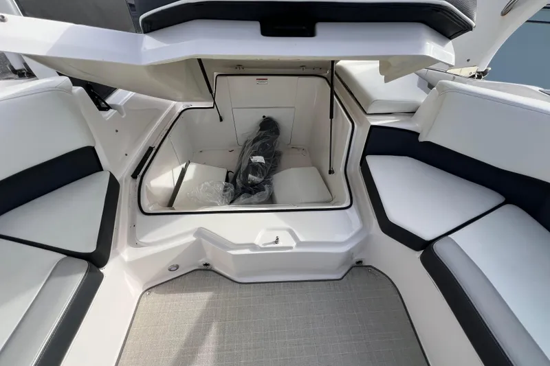 Slide: The Image of 2020 Regal 21 OBX boat interior storage compartment with seating and open hatch. - 10