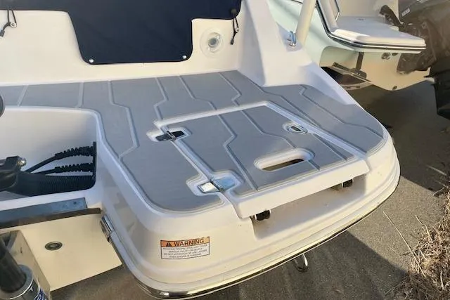 Slide: The Image of 2020 Regal 21 OBX boat swim platform with non-slip surface and warning label. - 12