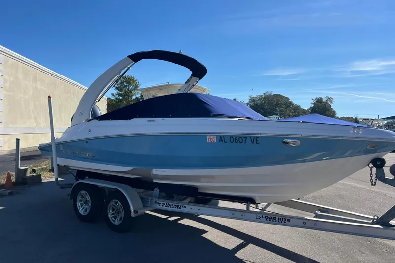 Slide: The Image of 2020 Regal 21 OBX boat on trailer, blue and white design, parked outdoors. - 2
