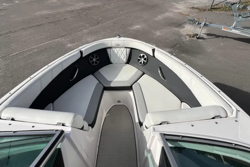 Slide: The Image of 2020 Regal 21 OBX boat interior with white and gray seating, docked on pavement. - 6